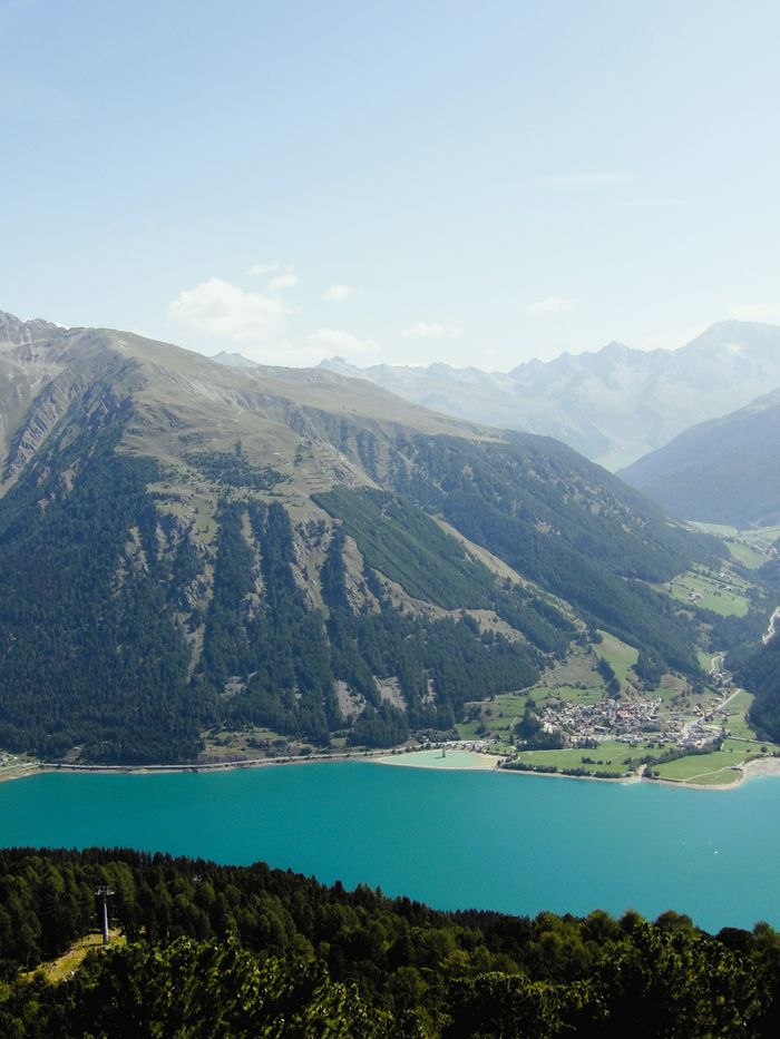 Breathtaking aerial view of Resia Lake and surrounding Alps in Trentino-Alto Adige, Italy.