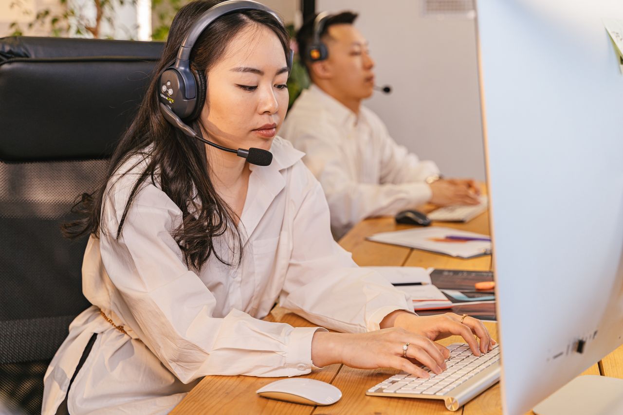 Call center professionals focused on tasks with headsets in a modern office setting.